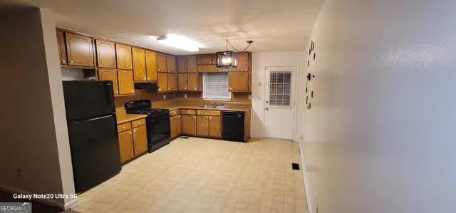 a kitchen with stainless steel appliances granite countertop a refrigerator a sink dishwasher a oven with cabinets and wooden floor