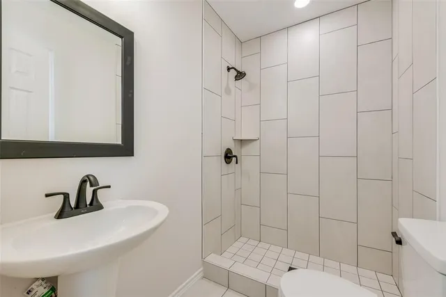 a bathroom with a sink a toilet and shower