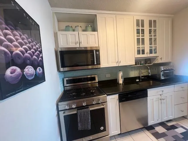 a kitchen with stainless steel appliances a stove a microwave and cabinets