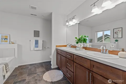 a spacious bathroom with a granite countertop sink a toilet and a mirror