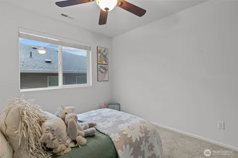 a bed in a bedroom next to a window and a chandelier