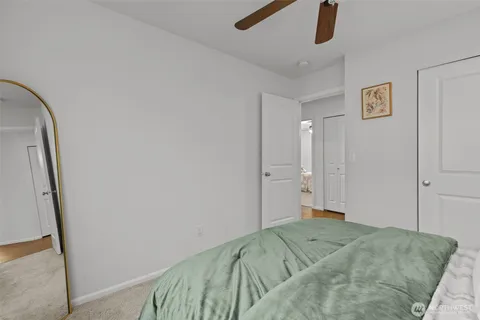 a bedroom with a bed and a chandelier fan