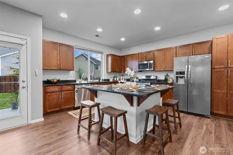a kitchen with a sink a refrigerator and wooden floor