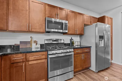 a kitchen with stainless steel appliances granite countertop a refrigerator stove top oven and sink