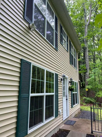 a view of a house with a large window and wooden fence
