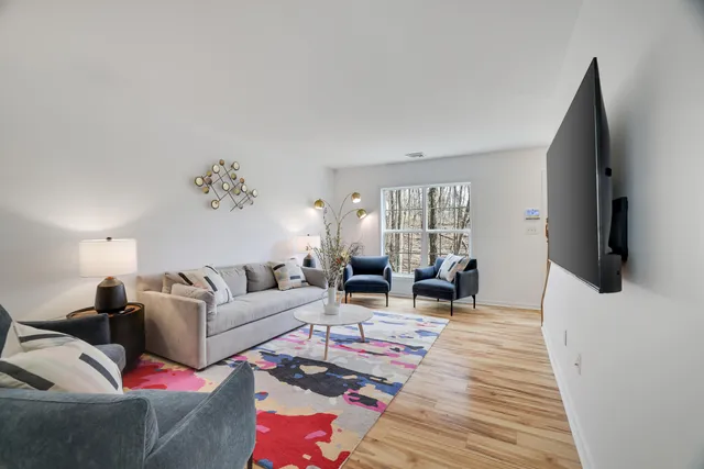 a living room with furniture wooden floor and flat screen tv