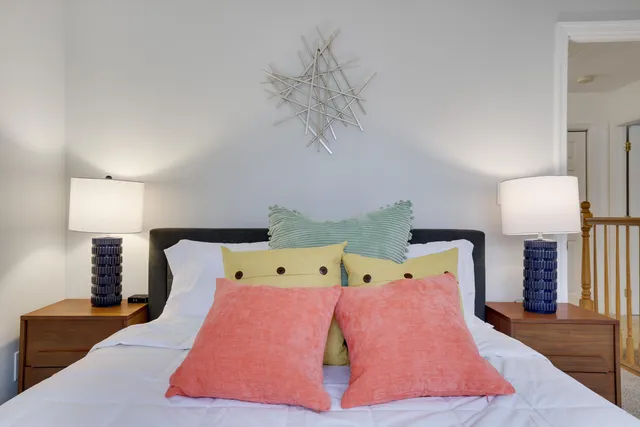 a bedroom with a large bed and a chair