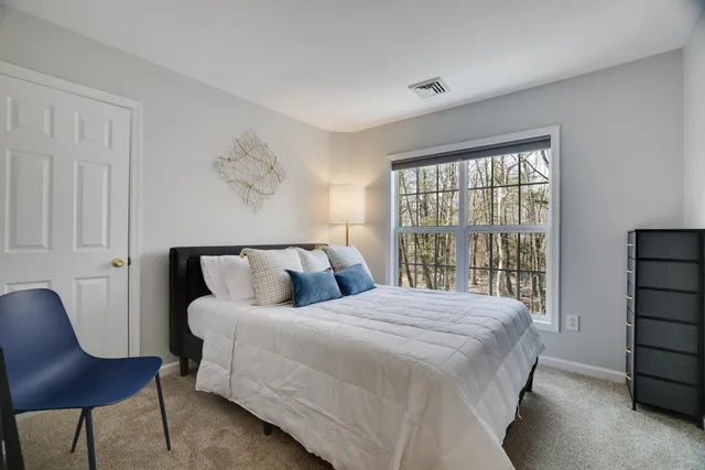 a bedroom with a bed and large window