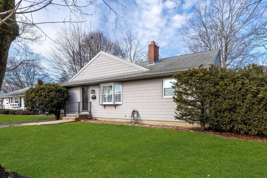 a front view of a house with a yard and trees