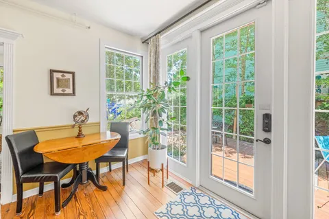 a view of a hallway with wooden floor and windows