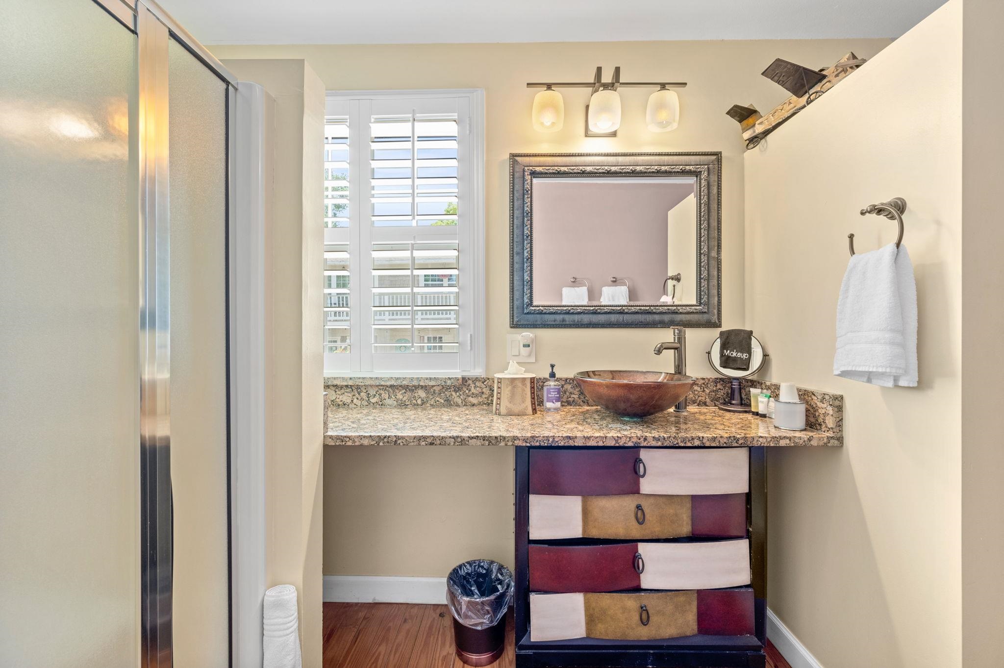 89 Cedar Street St. Augustine, FL 32084 - Photo 27 of 100 a bathroom with a granite countertop sink a mirror and a window