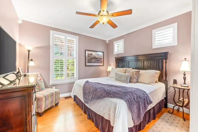 a bedroom with a large bed and a chandelier fan