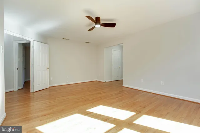 a view of an empty room and wooden floor and entryway