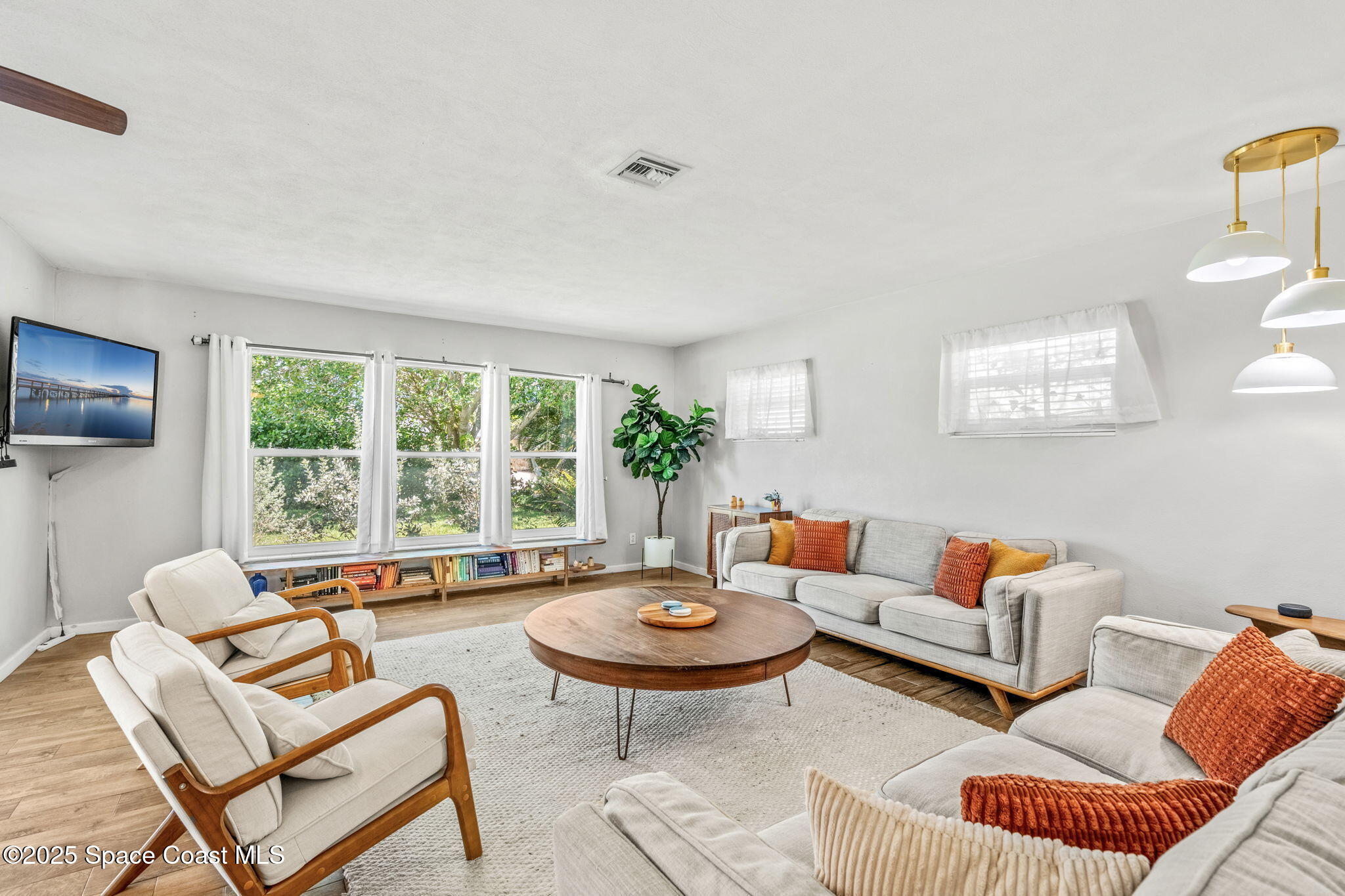 411 Poinsettia Road Melbourne Beach, FL 32951 - Photo 13 of 78 a living room with furniture a rug and a large window