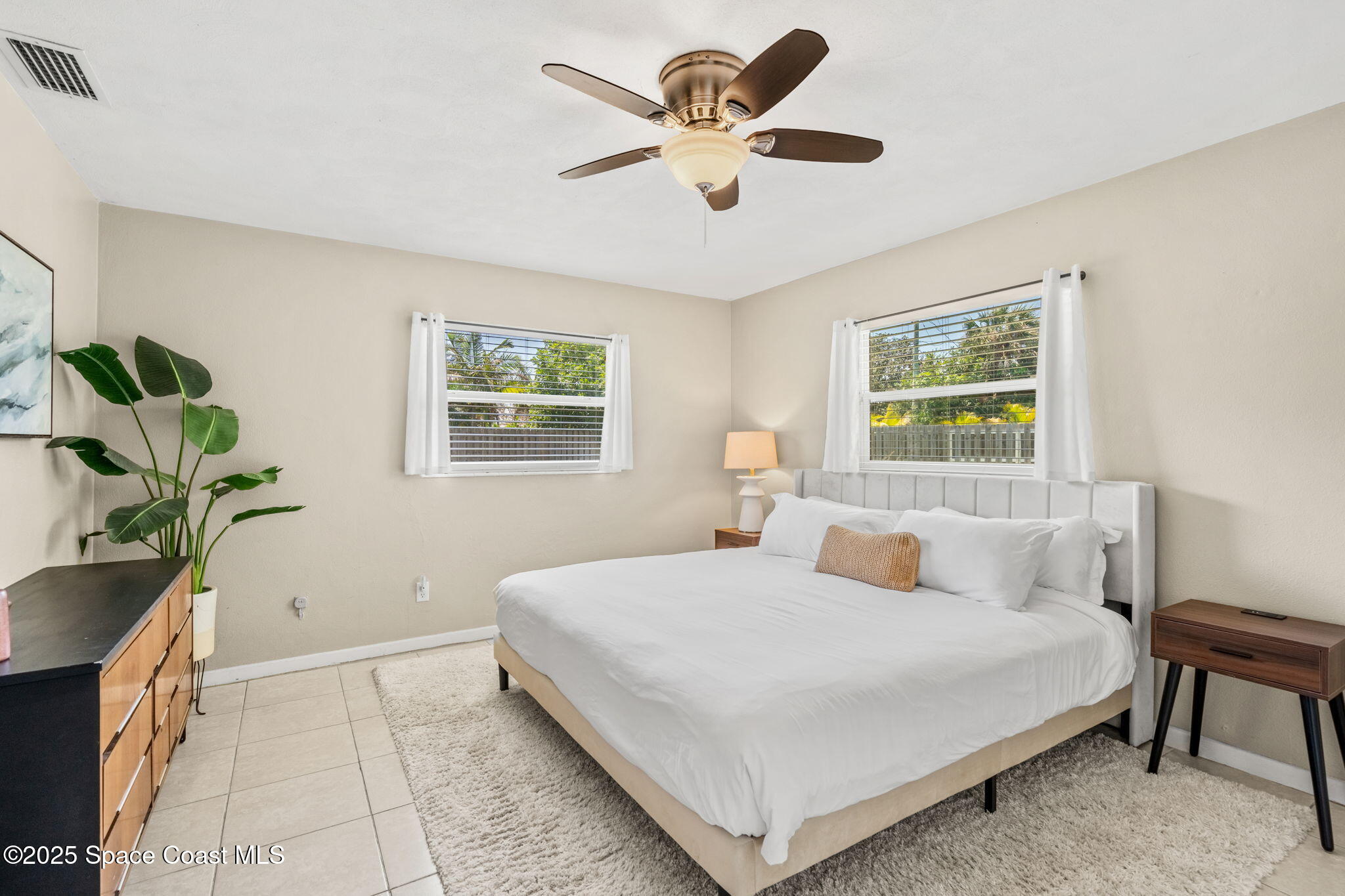 411 Poinsettia Road Melbourne Beach, FL 32951 - Photo 15 of 78 a bedroom with a bed and a potted plant