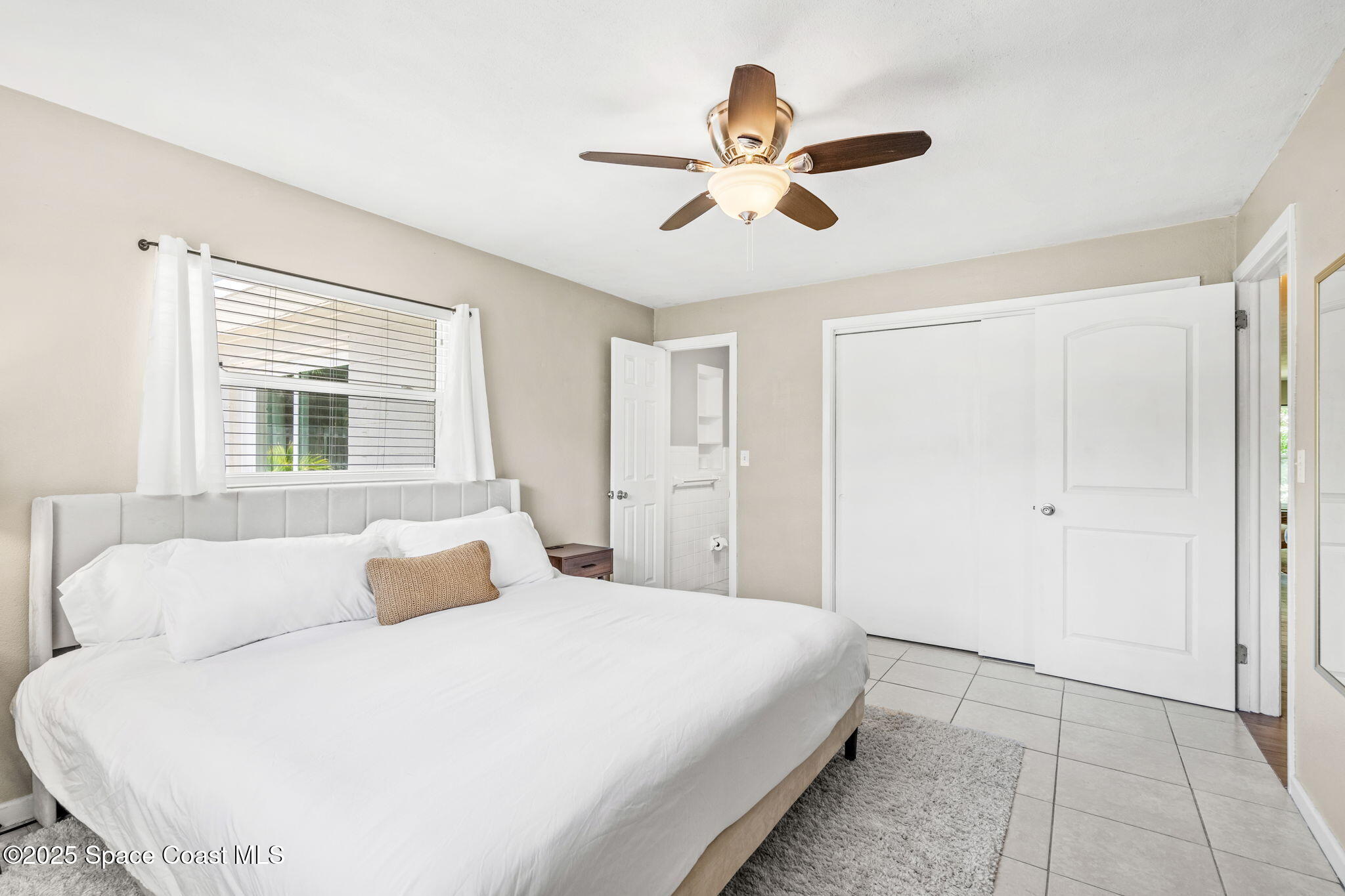 411 Poinsettia Road Melbourne Beach, FL 32951 - Photo 17 of 78 a bedroom with a large bed and a chandelier