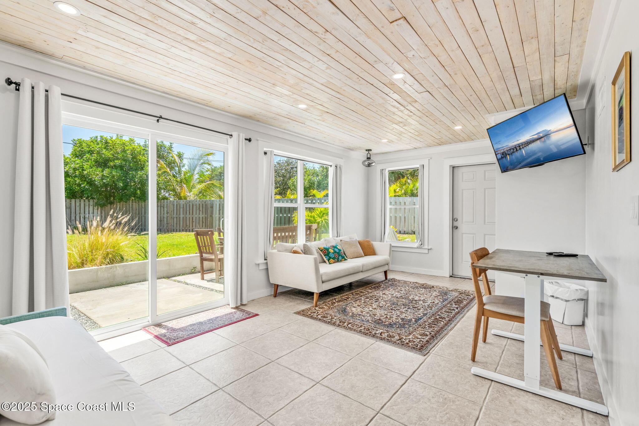 411 Poinsettia Road Melbourne Beach, FL 32951 - Photo 26 of 78 a living room with furniture and a floor to ceiling window