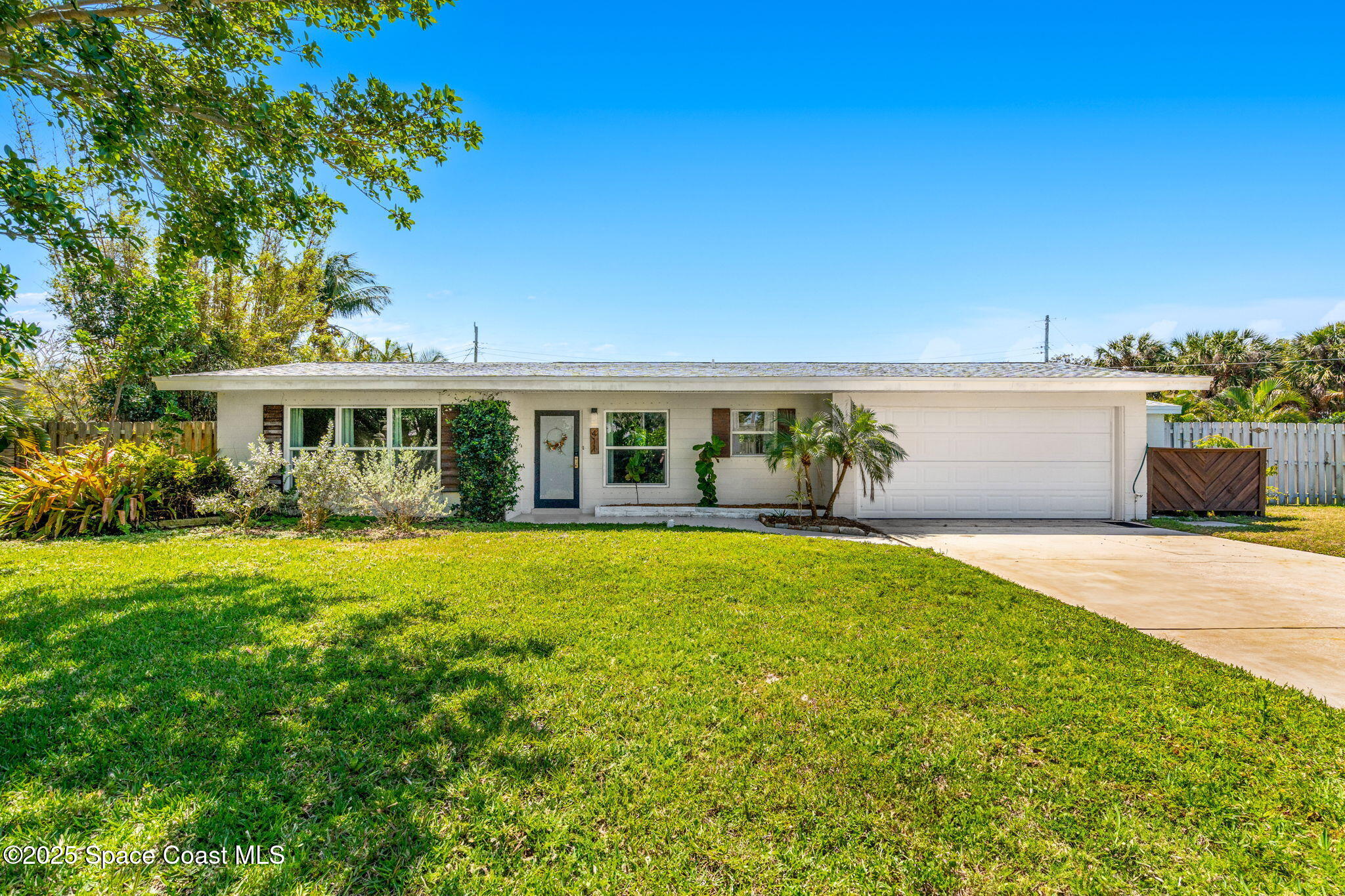411 Poinsettia Road Melbourne Beach, FL 32951 - Photo 35 of 78 a front view of house with yard and trees in the background