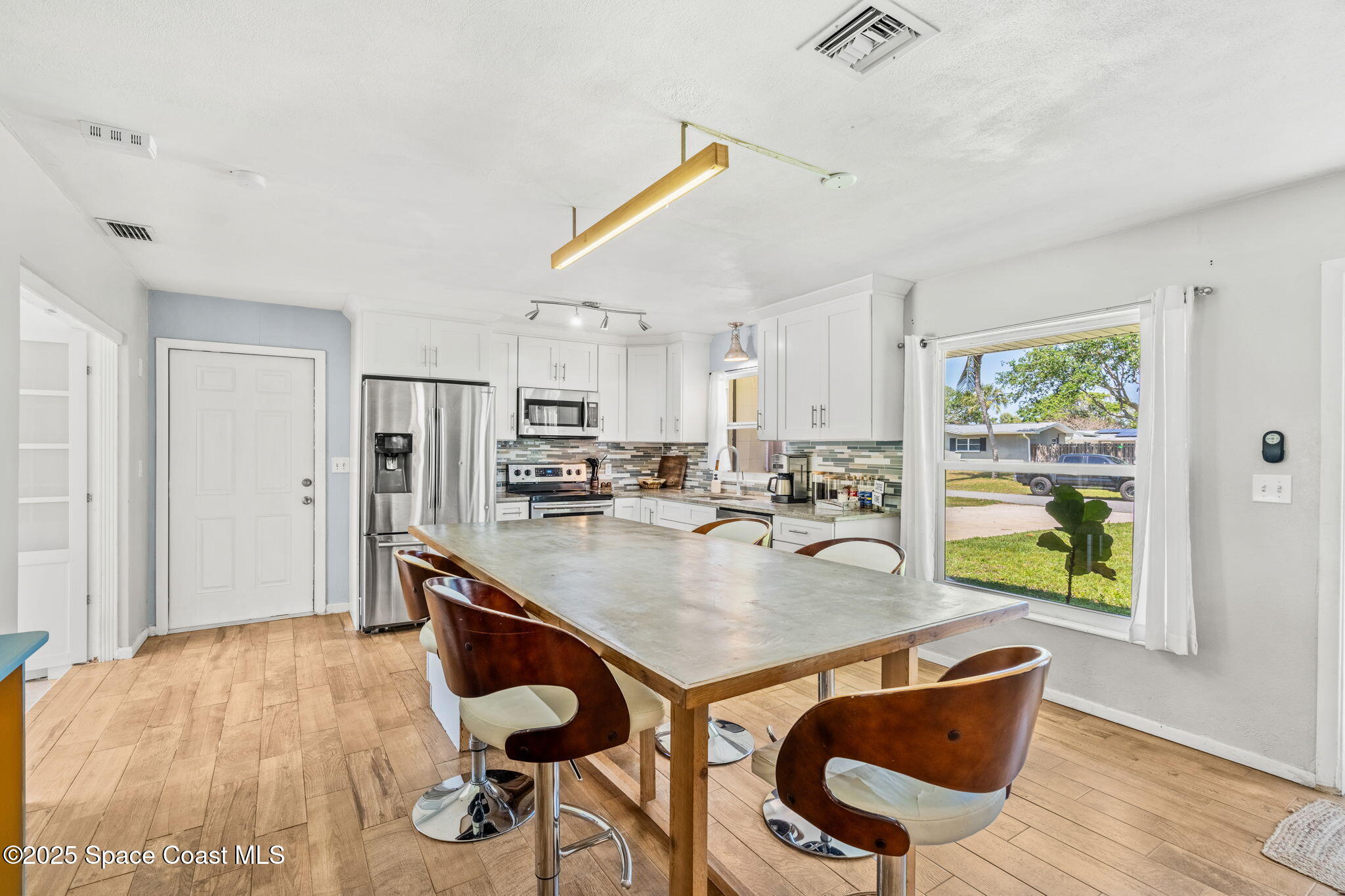 411 Poinsettia Road Melbourne Beach, FL 32951 - Photo 6 of 78 a dining room with furniture and wooden floor