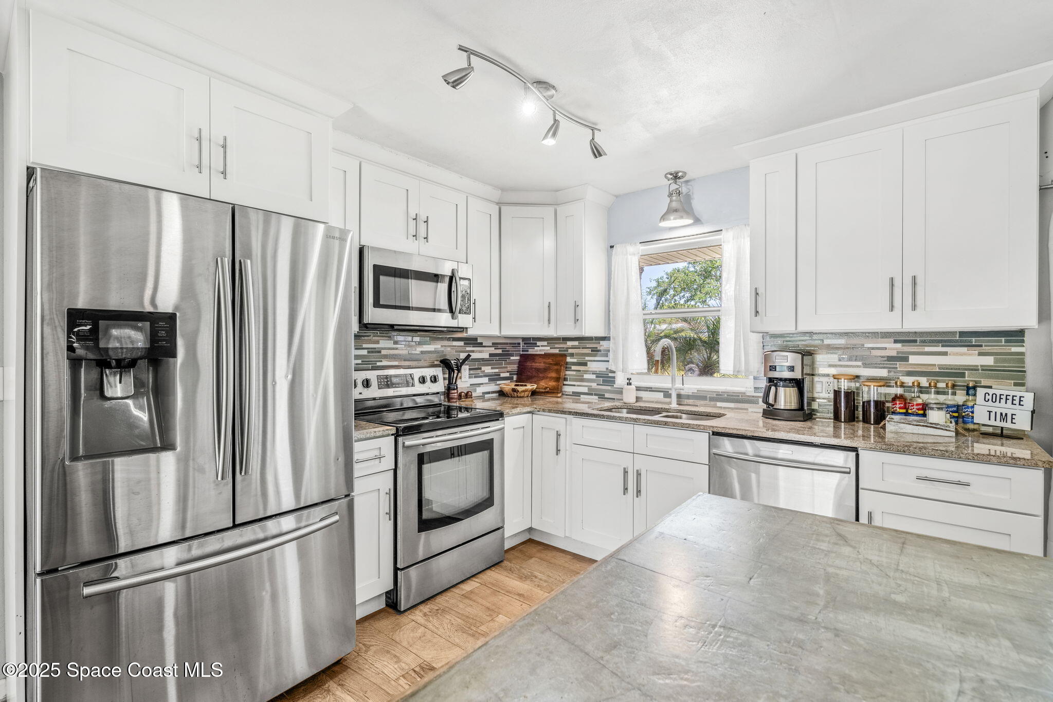 411 Poinsettia Road Melbourne Beach, FL 32951 - Photo 8 of 78 a kitchen with granite countertop stainless steel appliances and cabinets