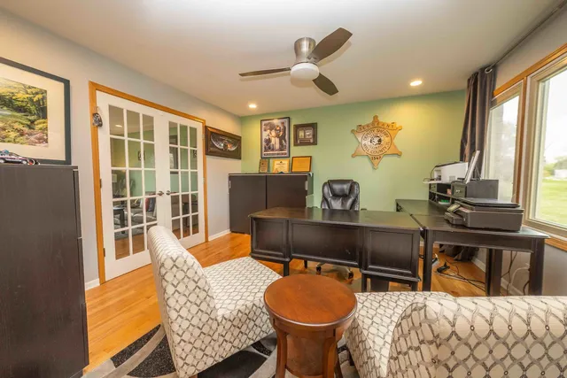 a living room with furniture a large window and wooden floor