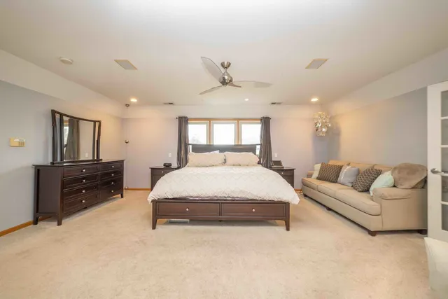 a spacious bedroom with a bed window and couch