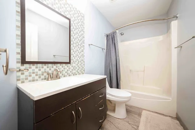 a bathroom with a sink a toilet and a mirror