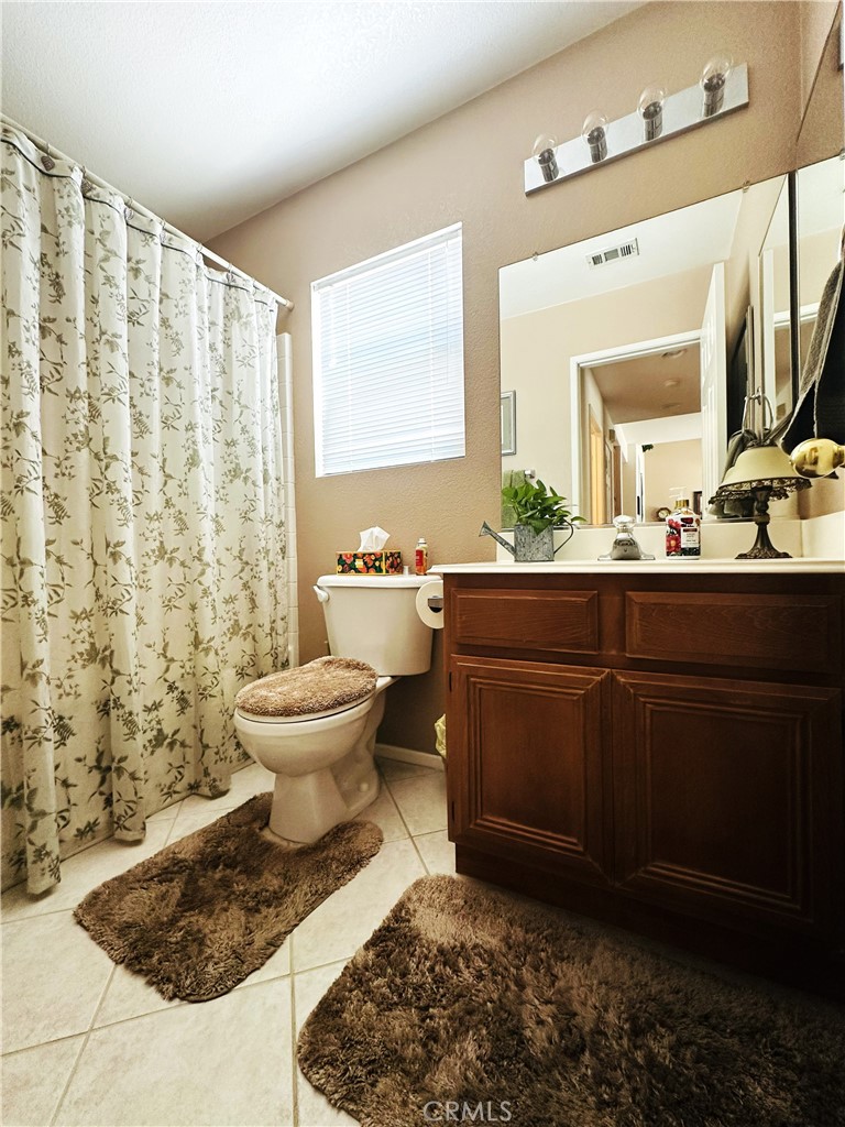 1665 Ravenswood Road Beaumont, CA 92223 - Photo 18 of 41 a bathroom with a sink toilet and mirror