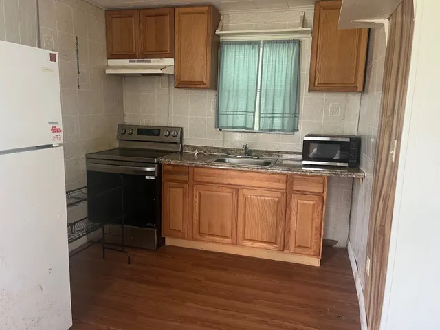 a kitchen with granite countertop a sink cabinets and stainless steel appliances