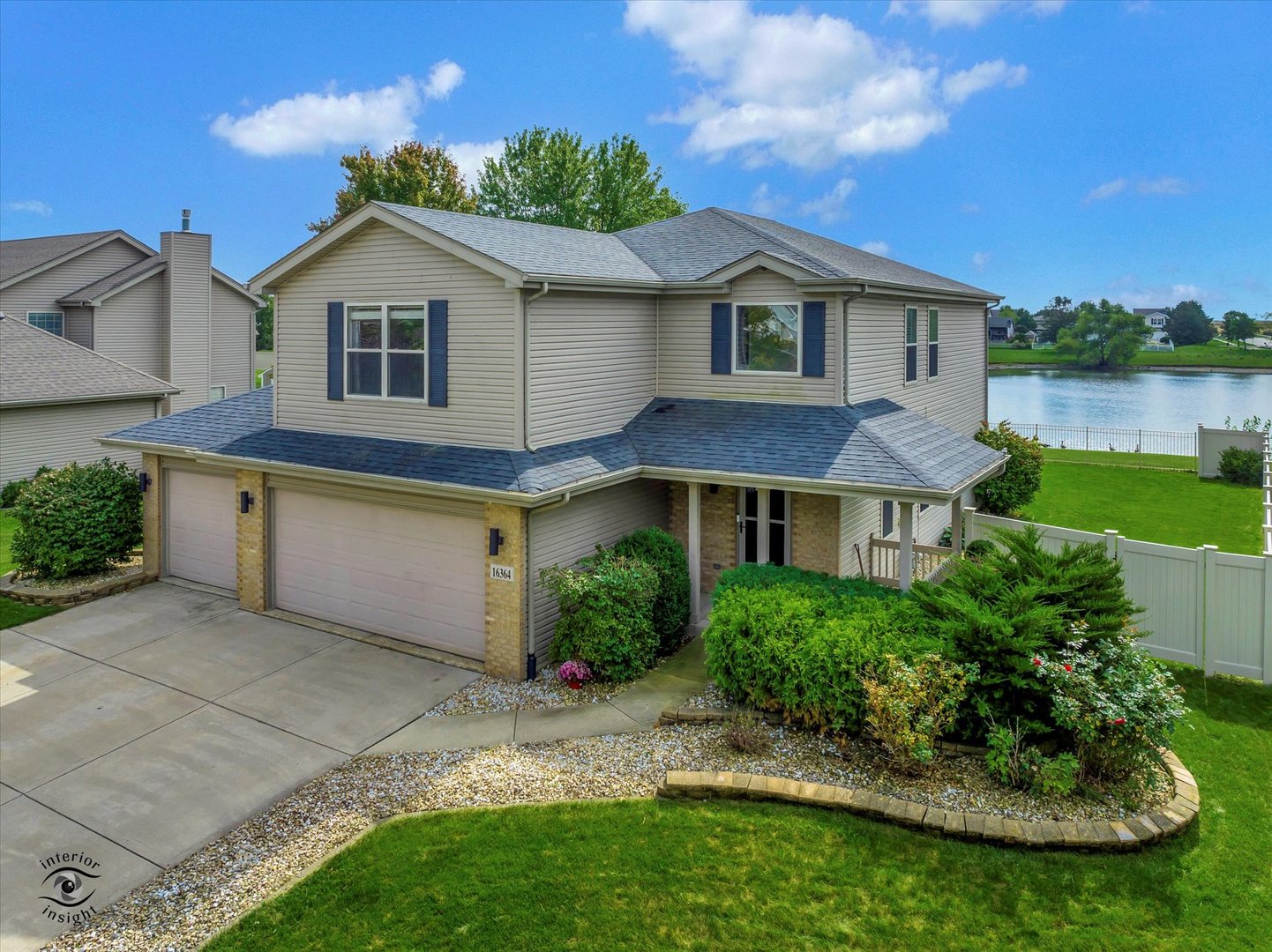 a view of a yard in front of a house with plants and large trees