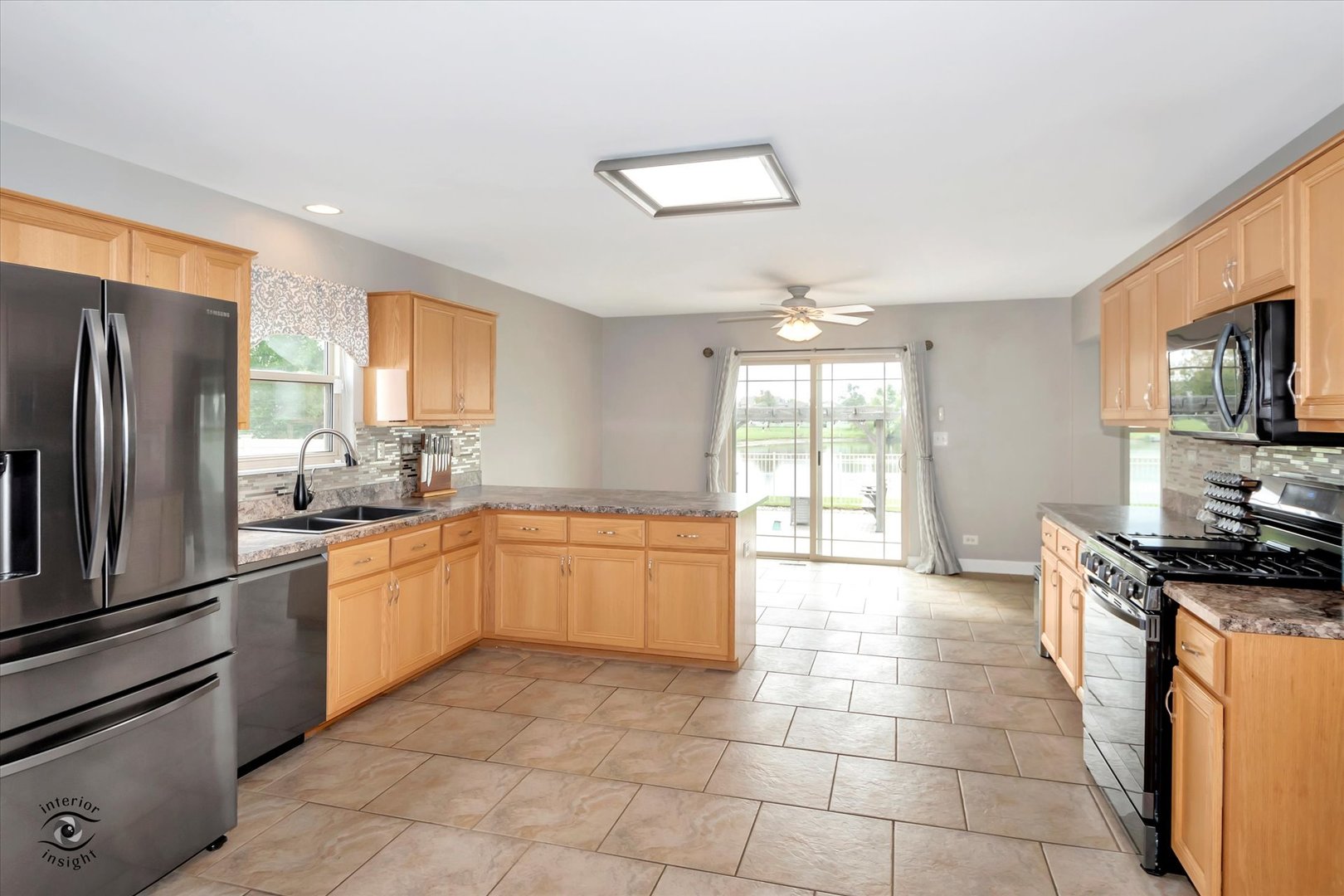 16364 Celtic Circle Manhattan, IL 60442 - Photo 12 of 31 a large kitchen with a stove a sink dishwasher a refrigerator and a stove top oven with wooden floor