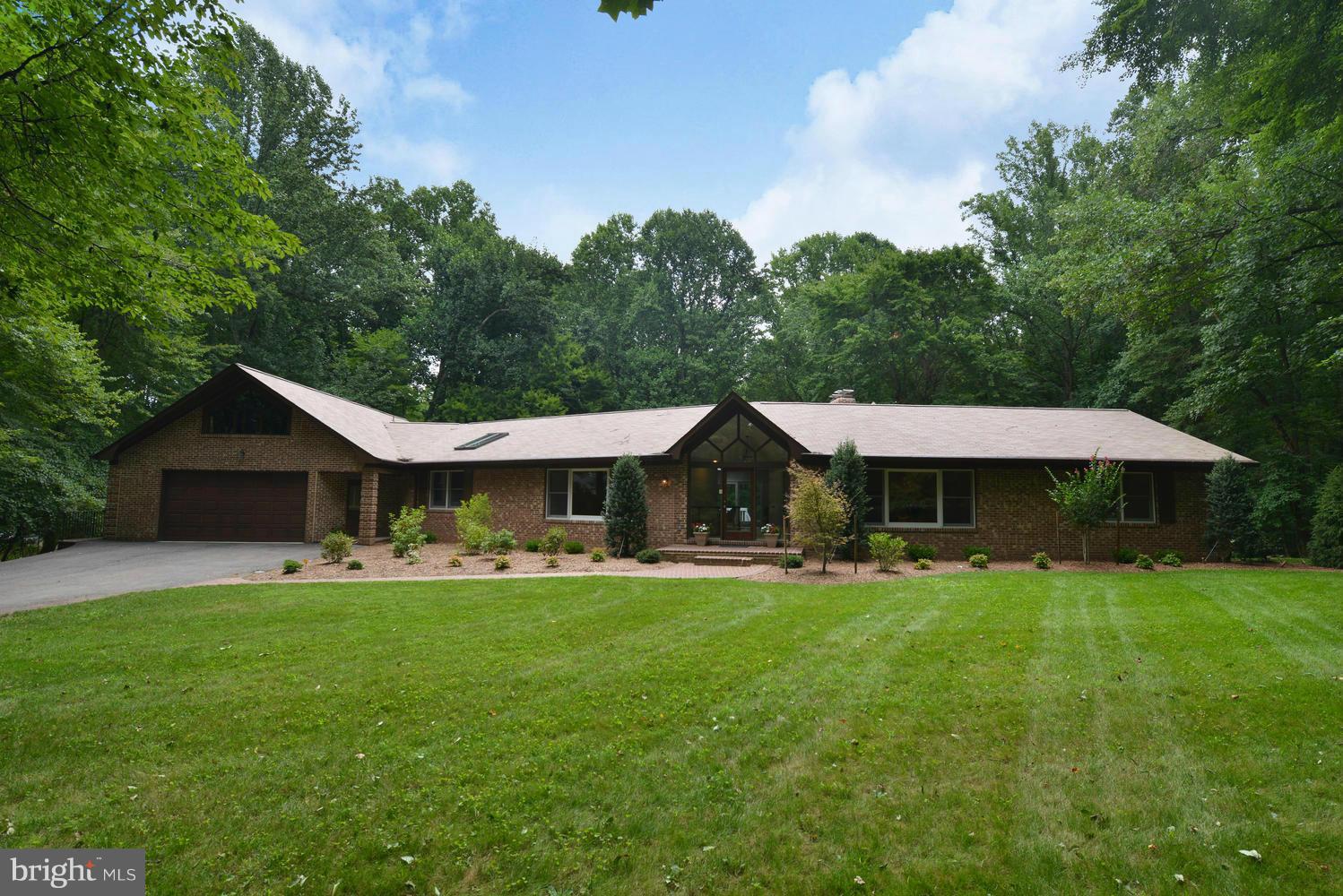 a front view of a house with a yard and trees