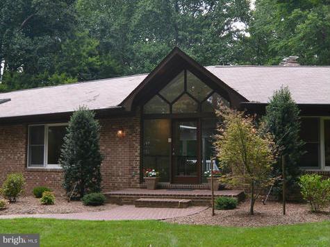 243 Springvale Road Great Falls, VA 22066 - Photo 2 of 30 a front view of a house with garden