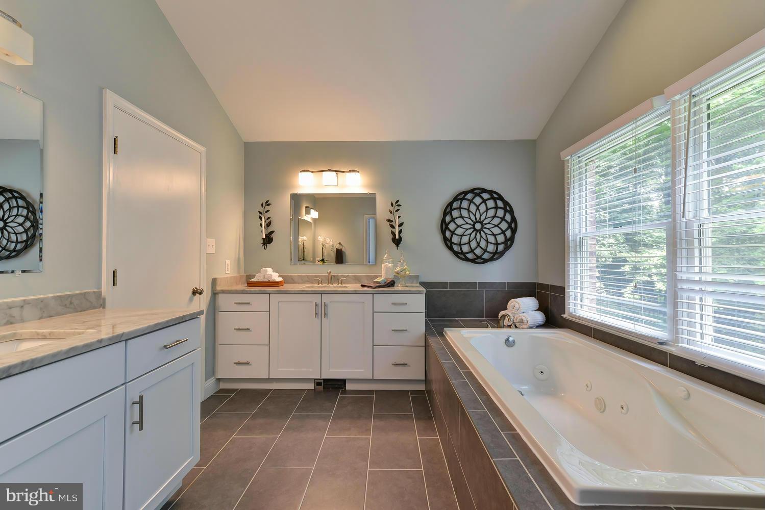 243 Springvale Road Great Falls, VA 22066 - Photo 16 of 30 a spacious bathroom with a granite countertop sink mirror and a bathtub