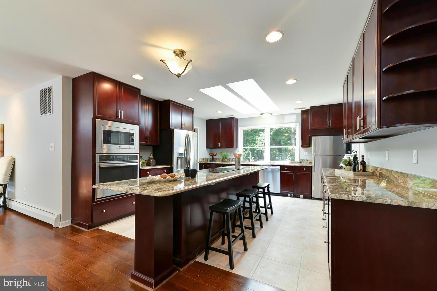 243 Springvale Road Great Falls, VA 22066 - Photo 8 of 30 a kitchen with stainless steel appliances granite countertop counter space cabinets and furniture
