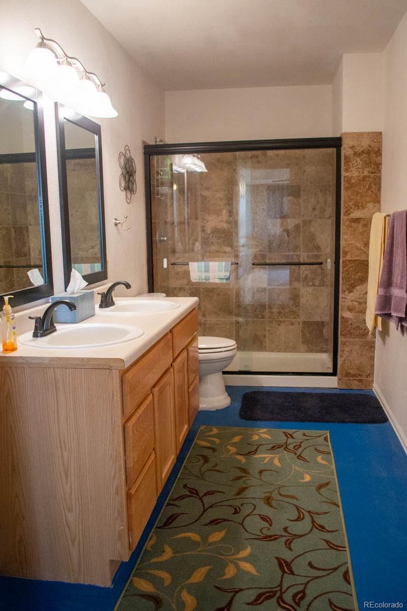 291 Turkey Ridge Road Walsenburg, CO 81089 - Photo 17 of 40 a bathroom with a double vanity sink a toilet and a mirror