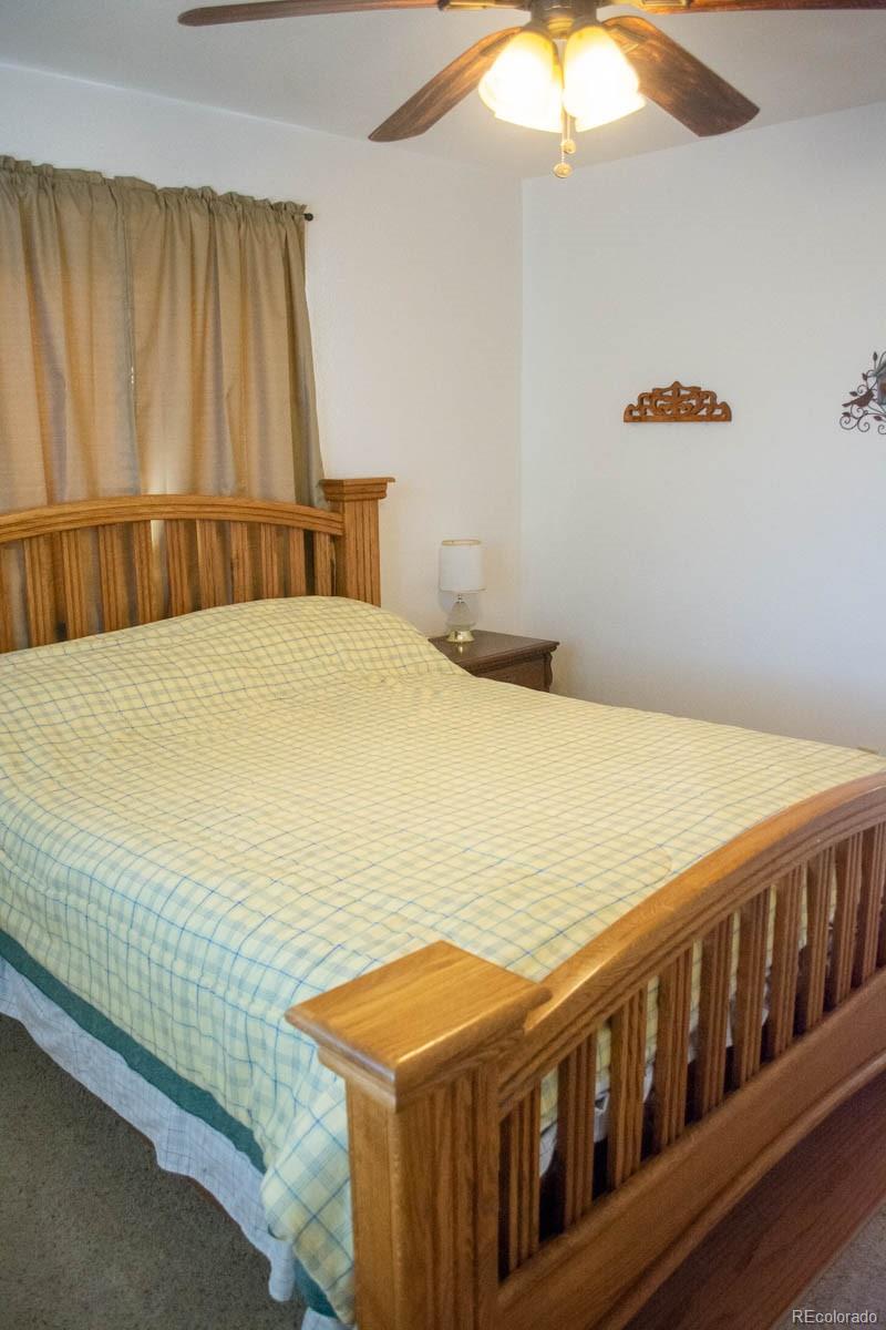 291 Turkey Ridge Road Walsenburg, CO 81089 - Photo 29 of 40 a bedroom with a bed and a chandelier