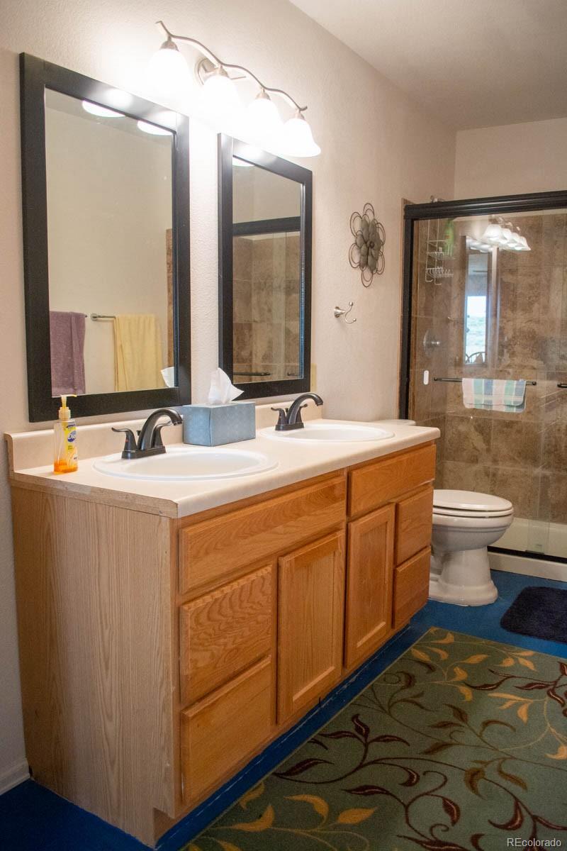 291 Turkey Ridge Road Walsenburg, CO 81089 - Photo 36 of 40 a bathroom with a double vanity sink a toilet and a mirror