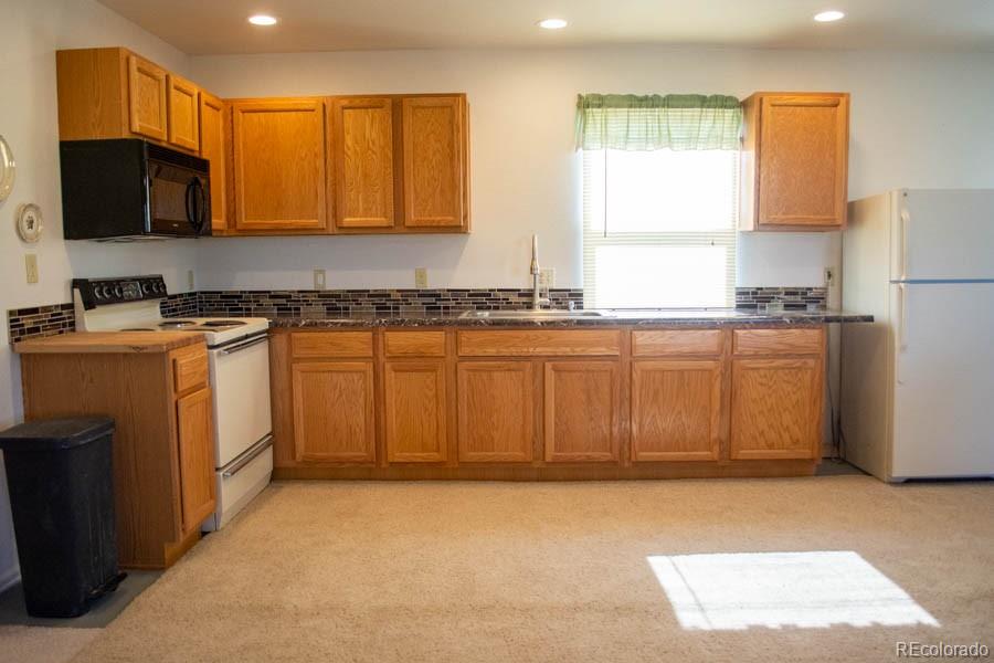 291 Turkey Ridge Road Walsenburg, CO 81089 - Photo 9 of 40 a kitchen with stainless steel appliances granite countertop a stove a sink a microwave a refrigerator and cabinets
