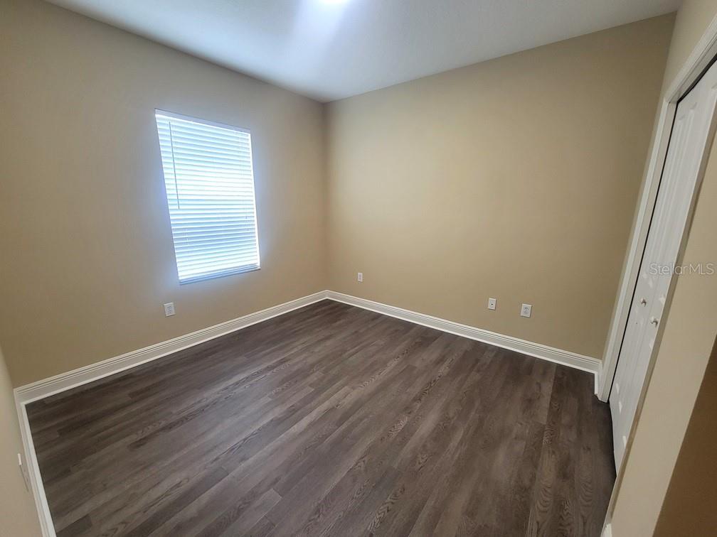 10418 Fenceline Road New Port Richey, FL 34655 - Photo 28 of 36 an empty room with wooden floor and windows