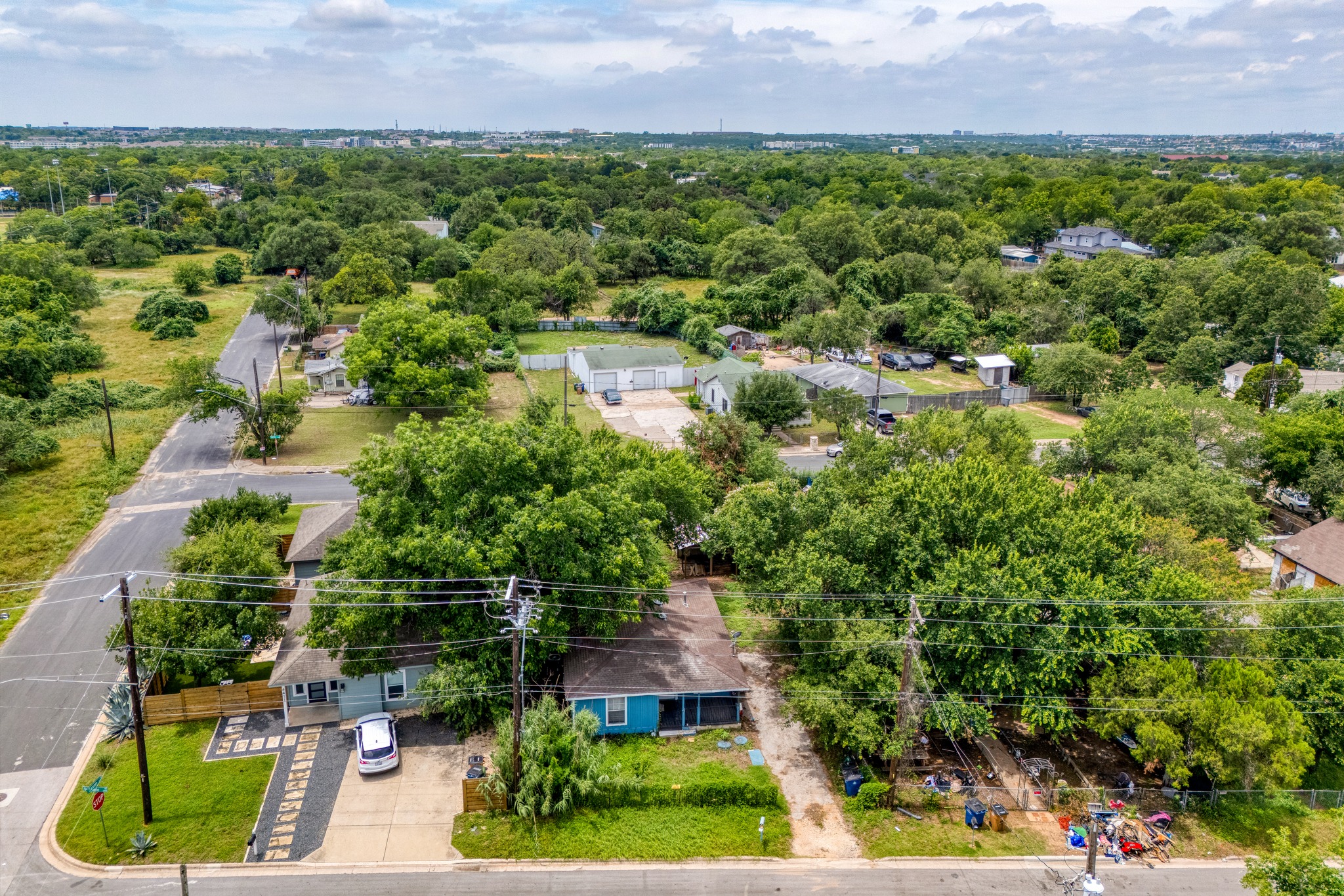 6409 Del Monte Road Austin, TX 78741 - Photo 10 of 15 An aerial perspective reveals a tree-lined neighborhood with scattered homes, verdant plots, and the distant urban edge.
