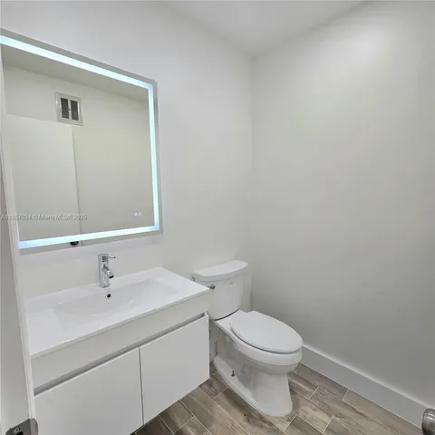 a bathroom with a toilet a sink and mirror