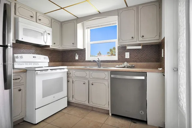a kitchen with white cabinets and white appliances
