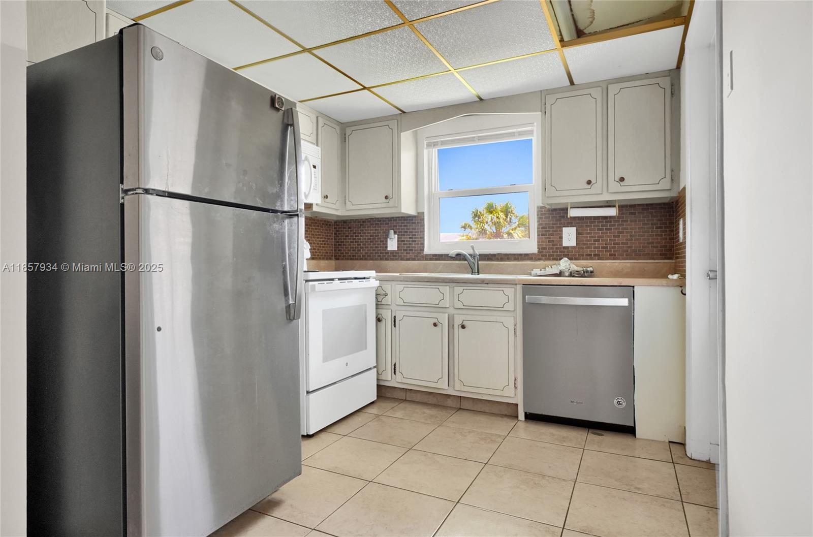 5300 Washington Street, Unit I205 Hollywood, FL 33021 - Photo 5 of 20 a kitchen with white cabinets and white appliances