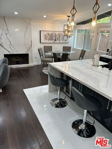 a kitchen with a sink a refrigerator and chairs