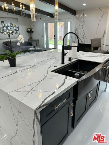 a kitchen with stainless steel appliances a sink a stove and a cabinets