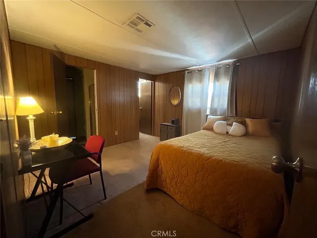 a spacious bedroom with a bed and a chandelier