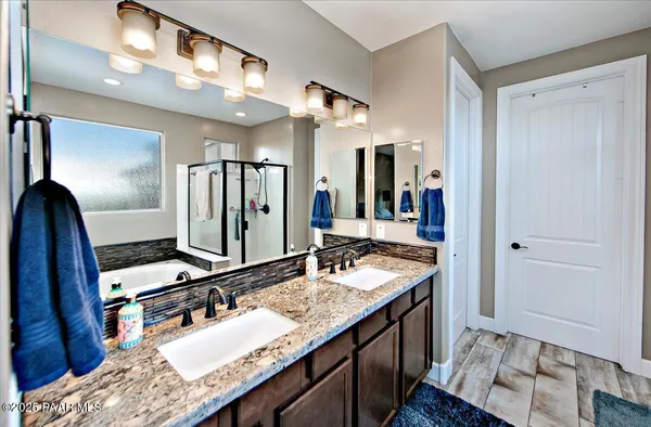 a bathroom with a granite countertop sink a mirror and shower