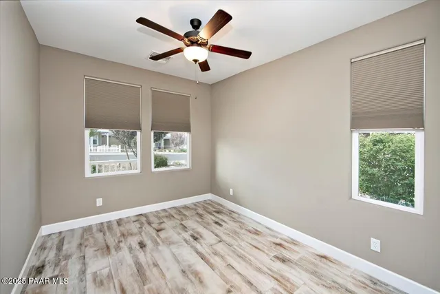 a view of a big room with wooden floor and a window