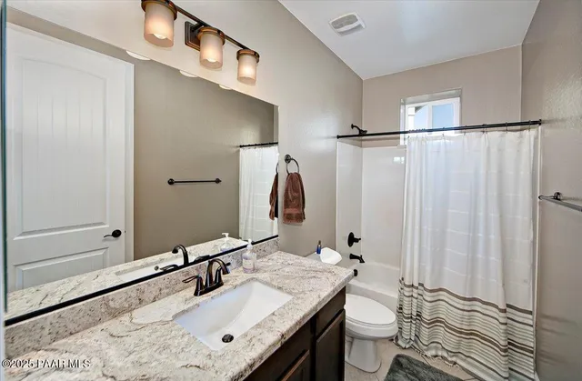 a bathroom with a sink vanity mirror and toilet